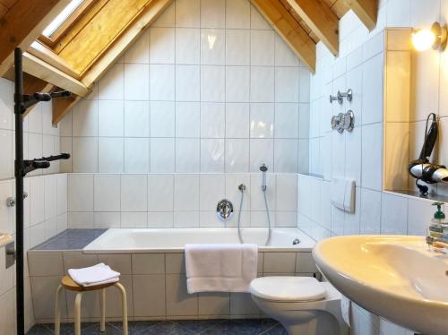 a bathroom with a tub and a toilet and a sink at 4-Sterne Ferienhaus Rösslewiese Hinterzarten in Hinterzarten