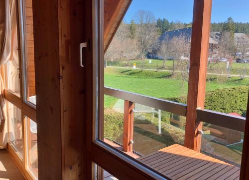 an open window with a view of a field at 4-Sterne Ferienhaus Rösslewiese Hinterzarten in Hinterzarten