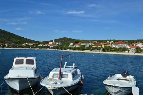 three boats are docked in a body of water at Apartmani Marino in Vinišće
