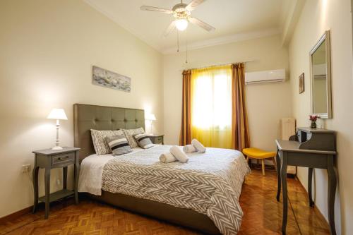 Schlafzimmer mit einem Bett, einem Schreibtisch und einem Fenster in der Unterkunft Androniki Apartment in Nafplio