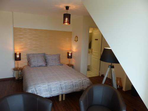 - une chambre avec un lit et deux chaises dans l'établissement LE RUBAN BLEU FACE A LA MER, à Arromanches-les-Bains