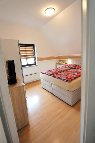 a bedroom with a bed and a flat screen tv at Aparthouse SUPREME with Terme Catez Swimming Pools Tickets in Čatež ob Savi
