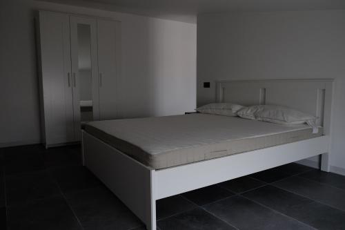ein weißes Bett in einem Schlafzimmer mit einer weißen Wand in der Unterkunft A due passi da una spiaggia meravigliosa in Crotone