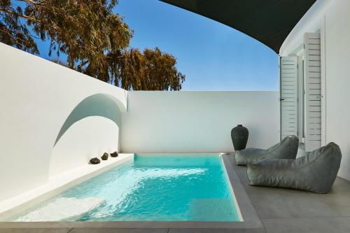a swimming pool in the middle of a house at Le Blanc Nest Santorini - Family / Couples Luxury House in Mesaria