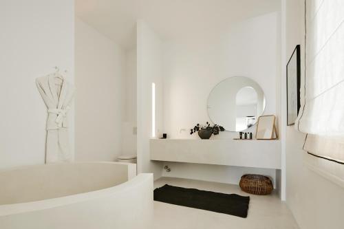 a white bathroom with a white tub and a mirror at Le Blanc Nest Santorini - Family / Couples Luxury House in Mesaria
