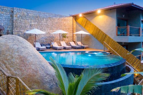 uma piscina com uma escada ao lado de um edifício em Hotel Vila Kebaya em Ilhabela