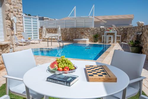 a table with a bowl of fruit next to a pool at Nofesh Ba Alon 10 in Rosh Pinna
