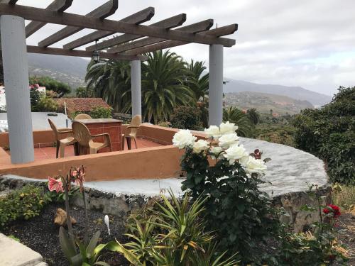 a garden with a pergola and a table and chairs at Casa Asuncion in Breña Alta