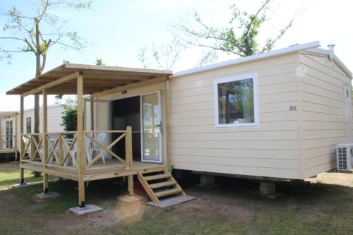 a tiny house with a porch and a staircase at Camping Klaus in Cavallino-Treporti