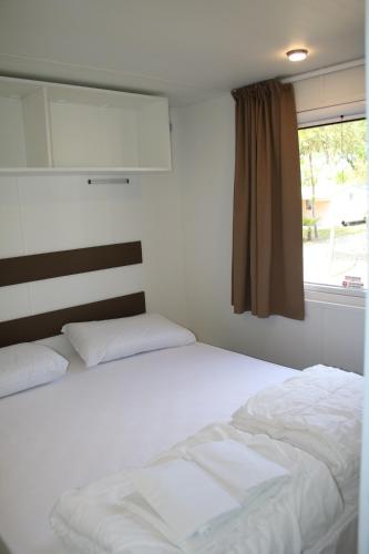 a bedroom with two white beds and a window at Camping Klaus in Cavallino-Treporti