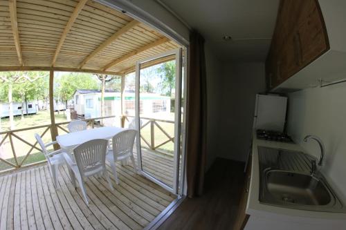 a kitchen with a table and chairs on a deck at Camping Klaus in Cavallino-Treporti