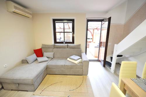a living room with a couch and a staircase at Aparthouse SUPREME with Terme Catez Swimming Pools Tickets in Čatež ob Savi
