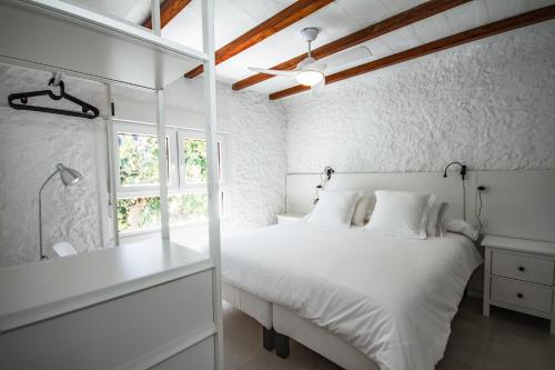 a white bedroom with a bed and a window at Las Nieves Blue in Agaete