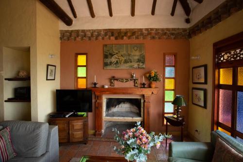 a living room with a fireplace and a tv at Casas La Primavera in Villa de Leyva