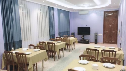 a conference room with tables and chairs and a television at Sunny Hotel Batumi in Makhinjauri