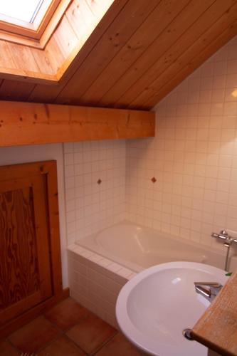 a bathroom with a bath tub and a sink at Chalet Gyronde in Vallouise