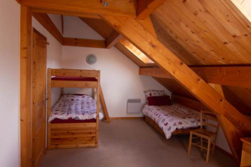 Cette chambre dispose de 2 lits superposés et de plafonds en bois. dans l'établissement Chalet Gyronde, à Vallouise