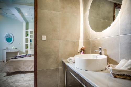 a bathroom with a sink and a mirror at Villa Sophie - Sunny Retreat! in Kalamaki