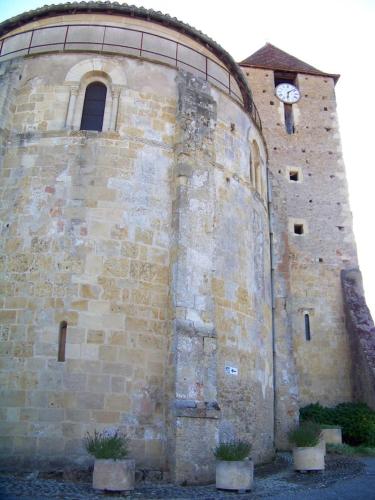 a building with a clock on the side of it at Gîte, jacuzzi & vin au grenier de Madiran in Madiran