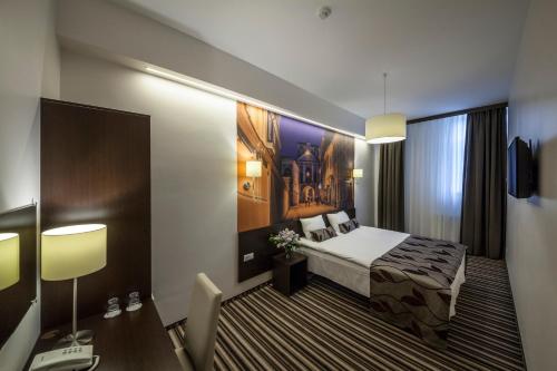a hotel room with a bed and a desk at Vilnius City Hotel in Vilnius