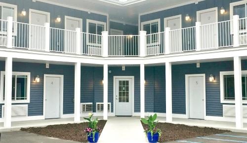 a blue building with white columns and balconies and plants at Empire Lakeshore Inn in Empire
