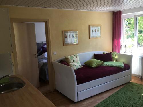 ein Wohnzimmer mit einem Sofa mit Kissen darauf in der Unterkunft Ferienwohnung Sonja am Weinberg in Radebeul