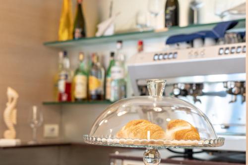two loaves of bread in a glass dish on a counter at Hotel Adigrat in Riccione