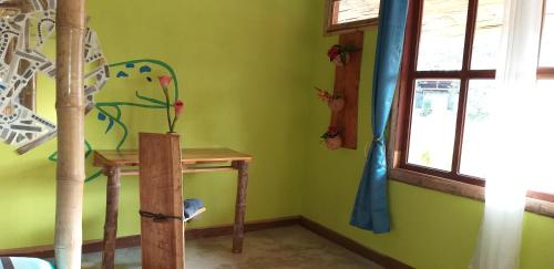 a room with green walls and a table and a window at Hotel Rio Celeste Finca L´ Etoile Celeste in El Achiote