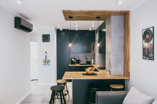 uma cozinha com um balcão e bancos num quarto em Harmonica - Luxury Apartment - A/C em Cracóvia