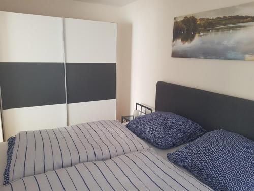 1 dormitorio con 1 cama y 2 almohadas azules en Ferienwohnung Berges, en Lago Éder