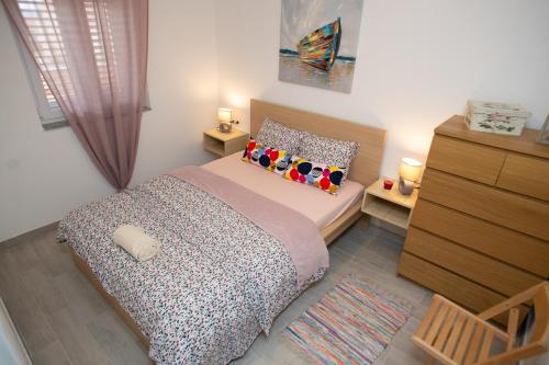 ein kleines Schlafzimmer mit einem Bett und einer Kommode in der Unterkunft Apartman Matej with pool Povljana in Povljana