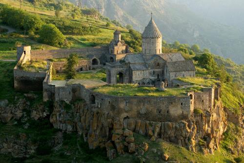 an old castle on a mountain with a church at Syunyats guest house in Halidzor
