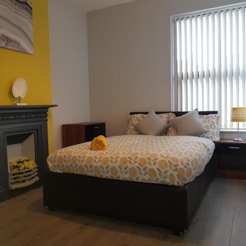 a bedroom with a bed and a fireplace and a window at Hollis House - 5 Bedroom Contractor Accommodation in Derby in Derby