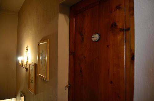 a hallway with a wooden door with a clock on it at Campo alle Monache in Bucine