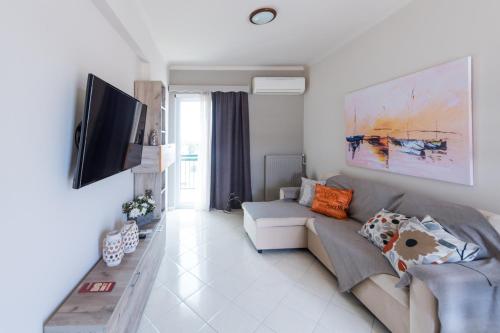 a living room with a couch and a flat screen tv at A & V Luxury apartment - Kalamata in Kalamata