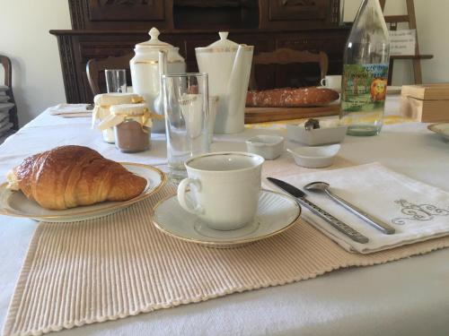 un tavolo con una tazza di caffè e un cornetto di La Huberdière a Fondettes