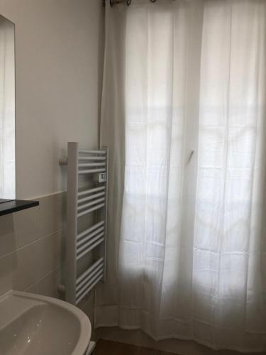 La salle de bains est pourvue d'un lavabo et d'un rideau de douche blanc. dans l'établissement New Saint Maur-Logement Lovely Flat 32m2, à Paris