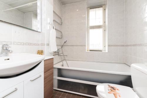 a white bathroom with a sink and a bath tub at Suurkarja Apartment in Tallinn