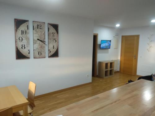 une chambre avec une horloge sur le mur et une personne assise sur le sol dans l'établissement Apartamento MyM, à Gijón