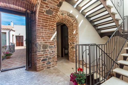 an entrance to a brick building with a staircase and flowers at Domo Pro Vois in Orosei