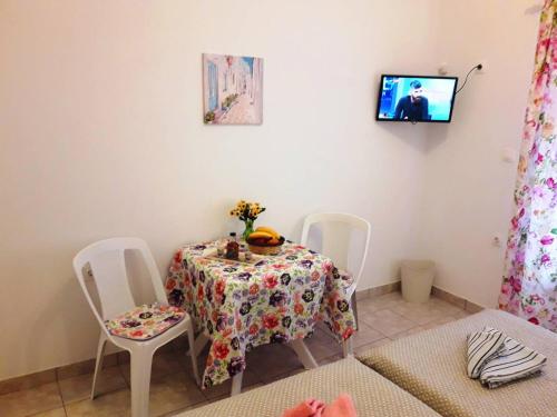 a dining room with a table and chairs and a tv at LARINΑKI'S STUDIO No1 in Amorgos