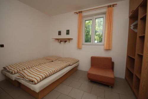 ロキトニツェ・ナト・イゼロウにあるNa Černém potoceのベッドルーム1室(ベッド1台、椅子、窓付)