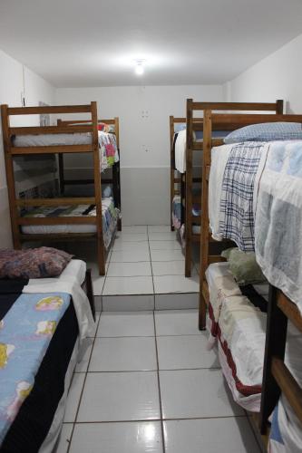 Habitación con varias literas y suelo de baldosa. en adriana hostel en Itacaré