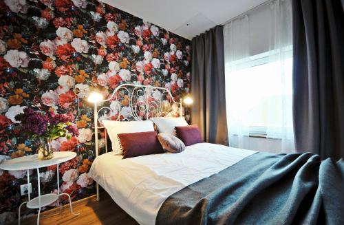 a bedroom with a bed and a floral wall at Sypialnia nad morzem in Kołobrzeg