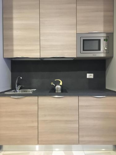 a kitchen with a sink and a microwave at APARTHOTEL CASA MIA in Milan
