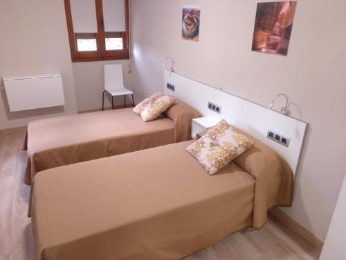 um quarto com duas camas e uma janela em Travesia Rooms em Sarria