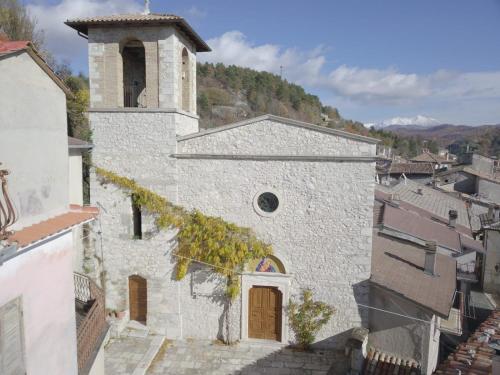 an old building with a clock tower in a town at B&B Ad un passo dal Cielo in Pietrasecca