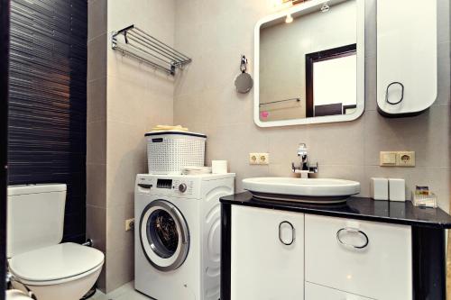 uma casa de banho com uma máquina de lavar roupa e um lavatório em Apartment Magnolia Rustaveli 62 em Batumi