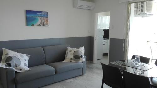 sala de estar con sofá y mesa en Grand studio climatisé en bord de mer avec parking sécurisé, en Golfe-Juan