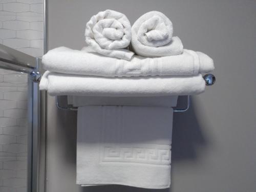 a stack of towels on a rack in a bathroom at Travesia Rooms in Sarria